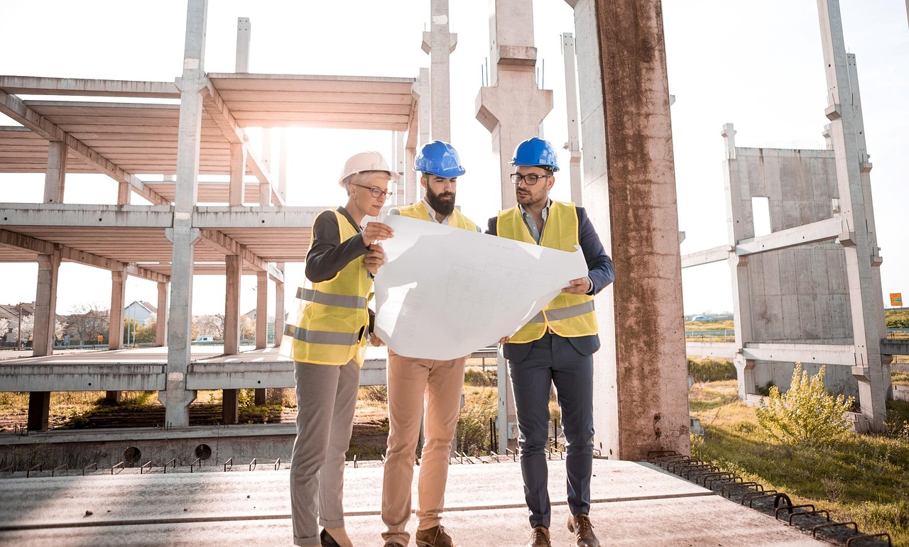 Equipo de construcción revisando planos en una obra en Piera